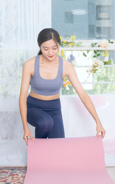 室內(nèi)女性整理瑜伽墊