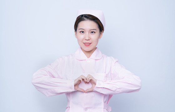 做愛(ài)心手勢(shì)的年輕女護(hù)士肖像