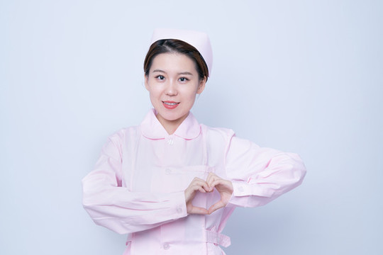 做愛(ài)心手勢(shì)的年輕女護(hù)士肖像
