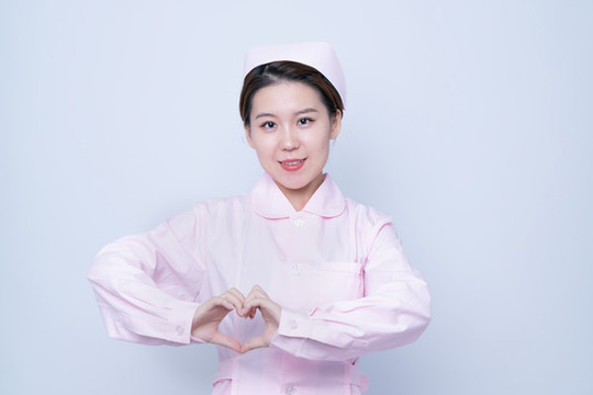 做愛(ài)心手勢(shì)的年輕女護(hù)士肖像