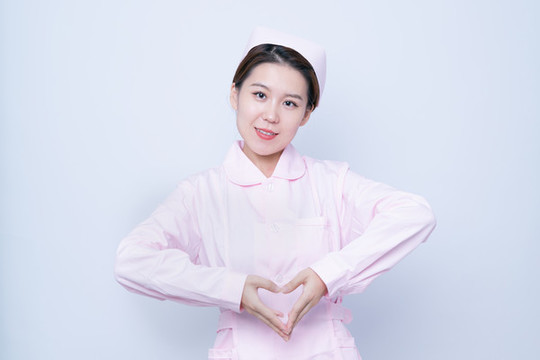 做愛(ài)心手勢(shì)的年輕女護(hù)士肖像
