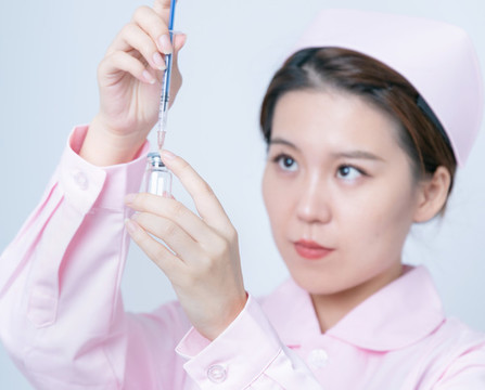 女醫(yī)護(hù)人員手持注射器和疫苗瓶