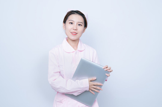 女護(hù)士手持筆記本電腦
