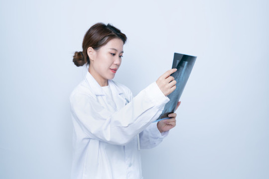 手持X光醫(yī)學照片的女醫(yī)生