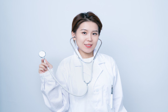 年輕女醫(yī)生手持聽診器