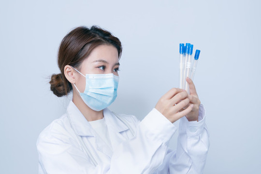 手持檢測樣本的年輕女醫(yī)生