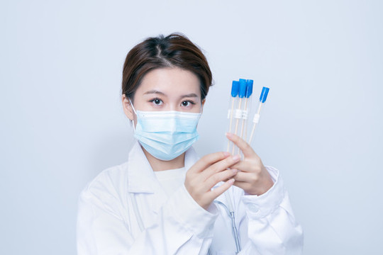 手持檢測樣本的年輕女醫(yī)生