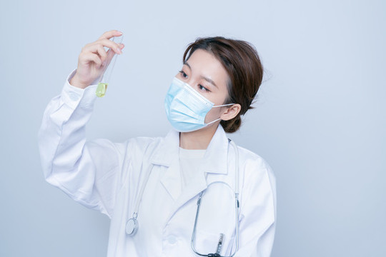 手持試管實驗的年輕女醫(yī)生