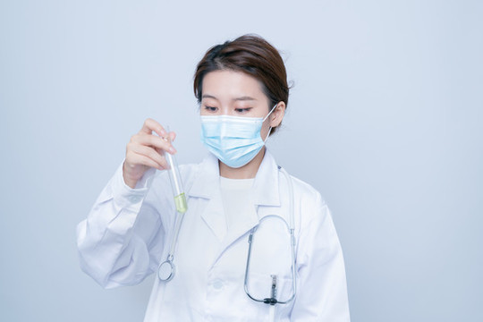 手持試管實驗的年輕女醫(yī)生