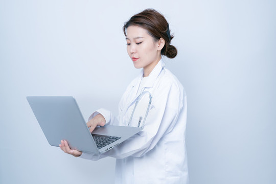女醫(yī)生使用筆記本電腦工作