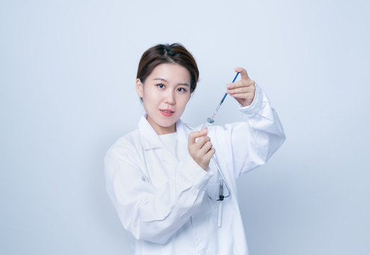 女醫(yī)生手持疫苗瓶和注射器