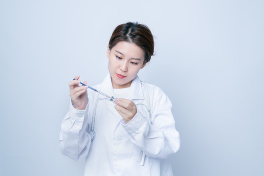 女醫(yī)生手持疫苗瓶和注射器