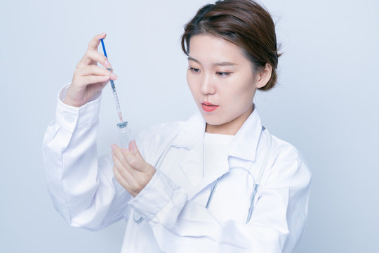 女醫(yī)生手持疫苗瓶和注射器