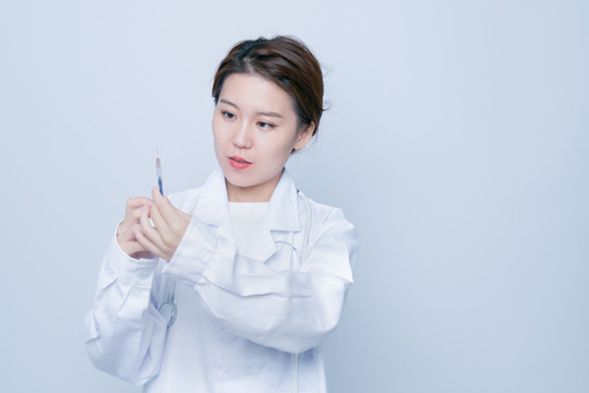 女醫(yī)生手持注射器