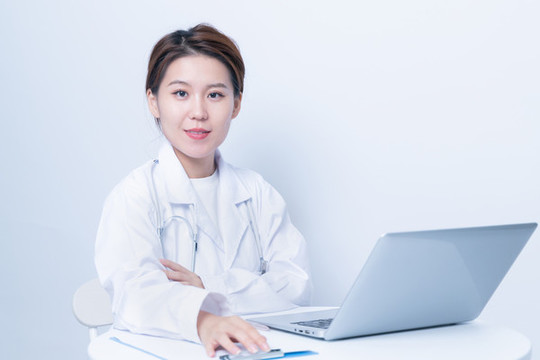 女醫(yī)生使用筆記本電腦工作