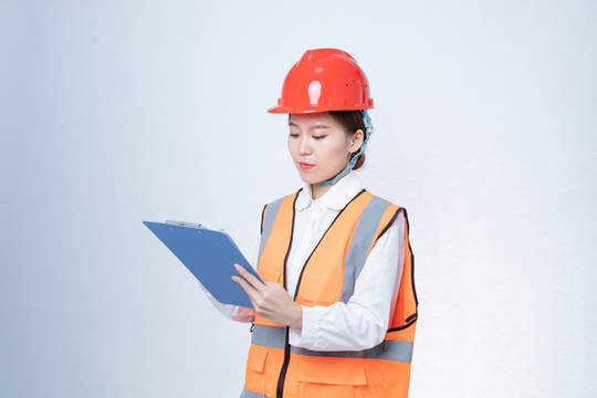 手持文件書寫的安全帽職業(yè)女性