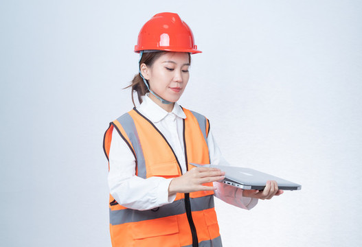 手持筆記本電腦的安全帽女性