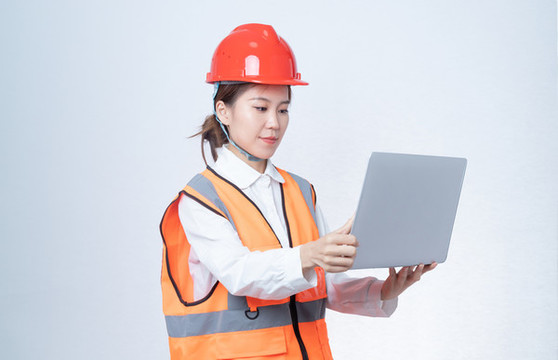 使用筆記本電腦的安全帽女性
