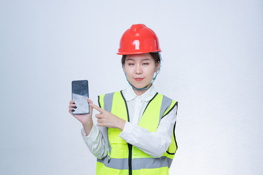 戴安全帽拿著手機的女性