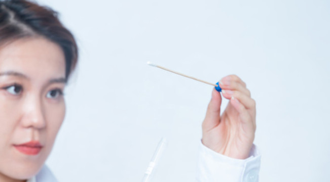 女醫(yī)生手持檢測拭子棉簽