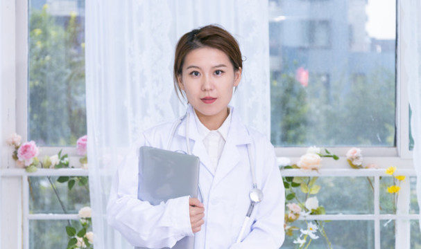 室內女醫(yī)生手持筆記本電腦