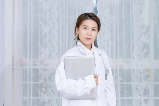 室內(nèi)女醫(yī)生手持筆記本電腦