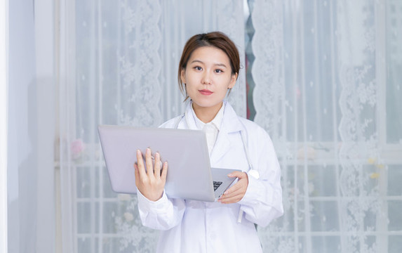 室內(nèi)女醫(yī)生使用筆記本電腦
