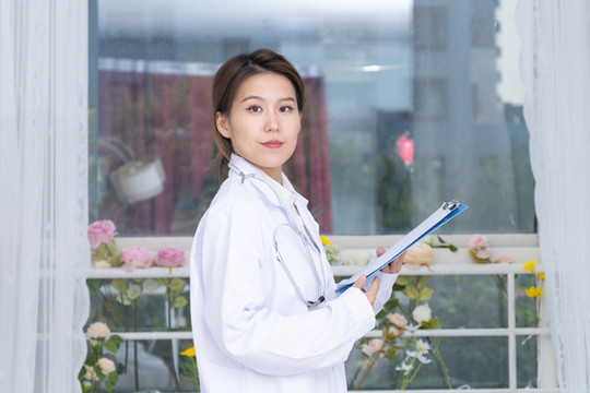 室內(nèi)窗前女醫(yī)生手持文件夾