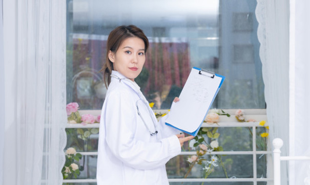 室內(nèi)窗前女醫(yī)生手持文件夾