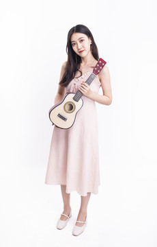 穿著連衣裙拿著尤克里里的女人