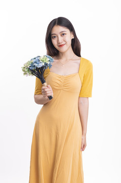 穿黃色連衣裙拿著一束花的女人