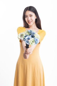 穿黃色連衣裙拿著一束花的女人
