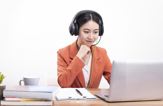 戴著耳機(jī)正在教網(wǎng)課的女老師