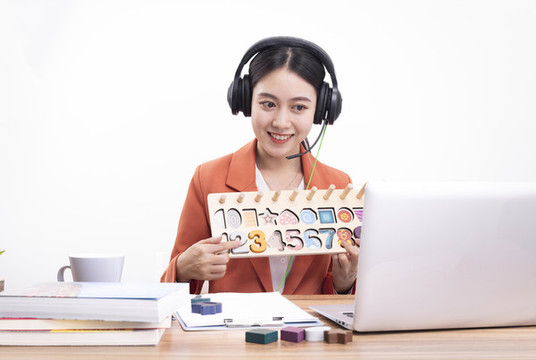 戴著耳機(jī)正在教網(wǎng)課的女老師