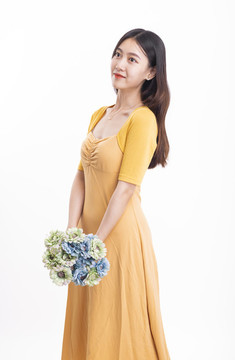 穿黃色連衣裙拿著一束花的女人