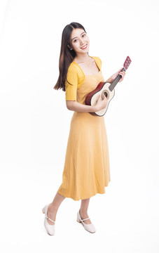 穿著連衣裙拿著尤克里里的女人