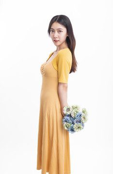 穿黄色连衣裙拿着一束花的女人