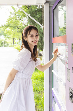 自動(dòng)售貨機(jī)旁的美麗東方女性