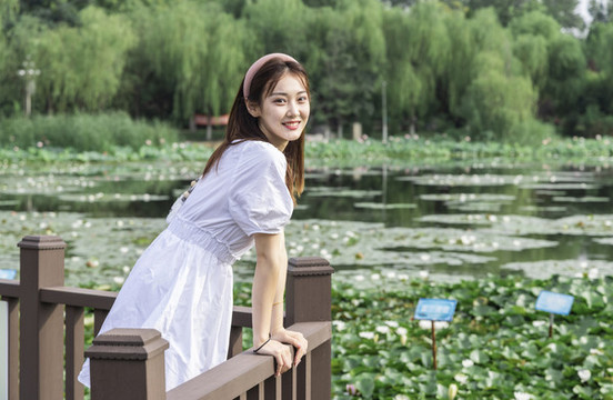 穿著白色連衣裙在湖邊的女孩