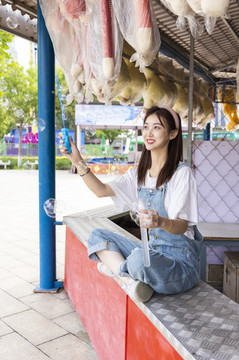 在游樂園里玩吹泡泡的美麗女孩
