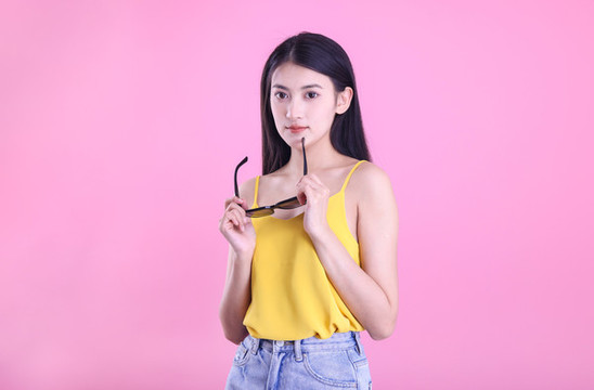粉色背景里戴著墨鏡的東方女孩