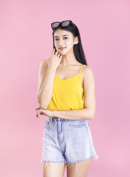 粉色背景里戴著墨鏡的東方女孩
