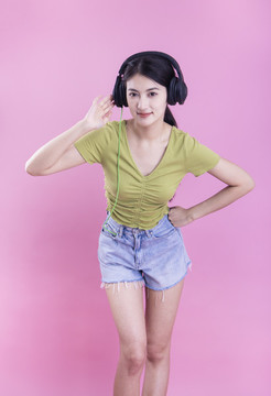 粉色背景里戴著耳機的亞洲美女