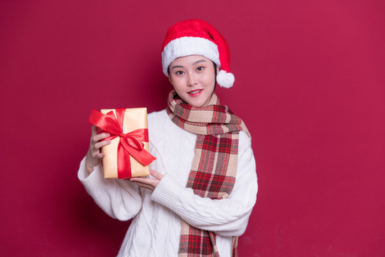 帶著圣誕帽的女性拿著禮盒