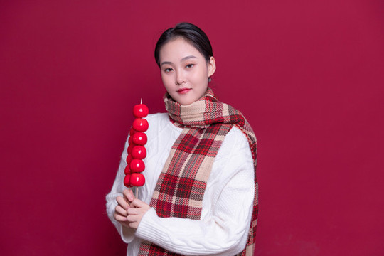 手持冰糖葫蘆的年輕女性