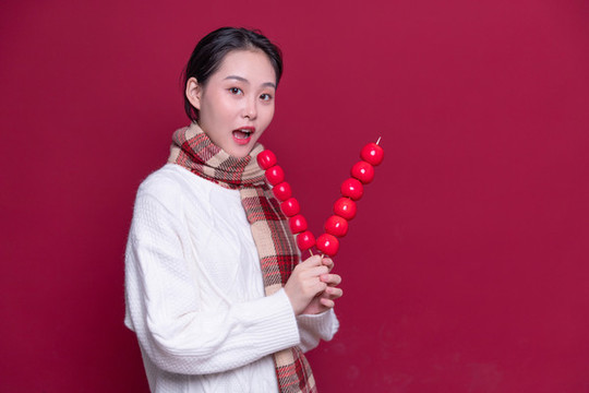 手持冰糖葫蘆的年輕女性