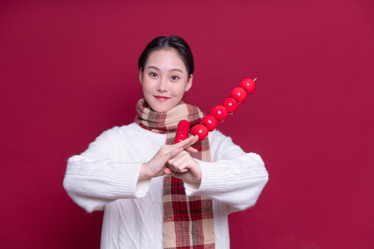 手持冰糖葫蘆的年輕女性