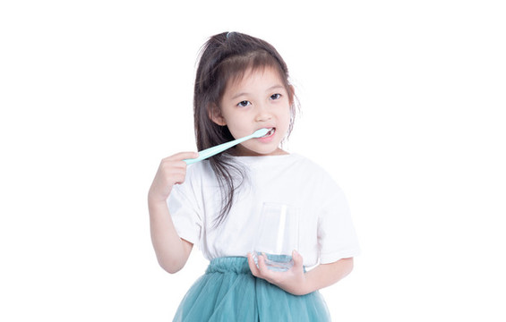 手持水杯刷牙的小女孩
