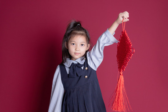 拿著中國結(jié)的可愛小女孩