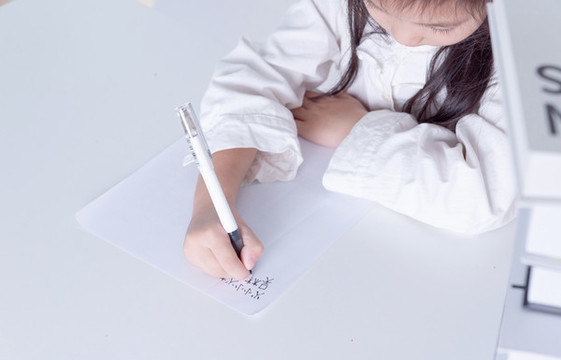 書桌上寫作業(yè)的小女孩